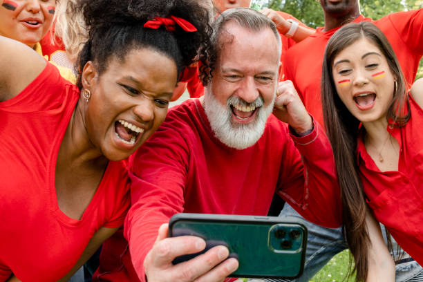 istock Supporters watching their team win the game on a mobile phone 2158204672