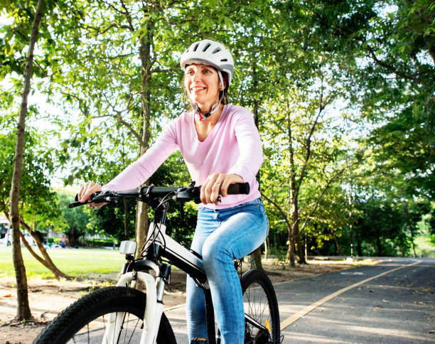 istock Woman enjoying a bicycle ride in the park 2158205115