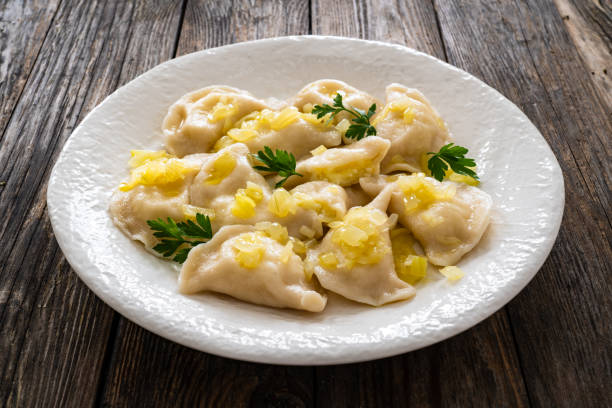 istock Russian potato dumplings with fried onion on white plate on wooden table 2158205887