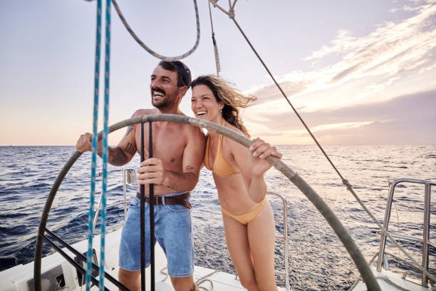 istock Cheerful couple having fun while driving a boat at sea. 2158206314