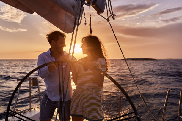 istock Happy couple toasting while driving a yacht at sunset. 2158206713