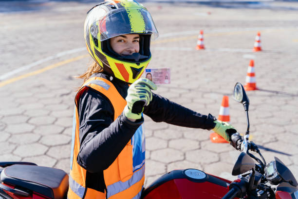 istock Student showing motorcycle driving license as successfully finished riding lessons. 2158207981