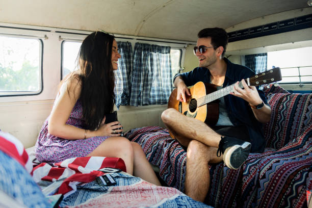 istock Man Playing Guitar with Lover in a Van Road Trip 2158208257