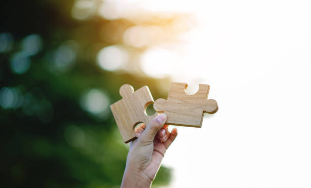 istock Wooden jigsaw puzzle, cooperation and teamwork, unity among groups and inspiration for good work. 2158208452