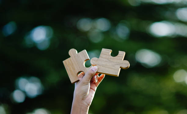 istock Wooden jigsaw puzzle, cooperation and teamwork, unity among groups and inspiration for good work. 2158208488