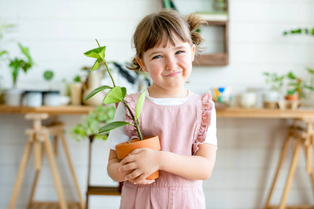 istock Potted plants at home held by a cute kid 2158208572