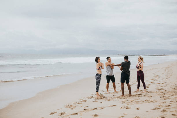 istock Diverse friends stretching at the beach 2158212495