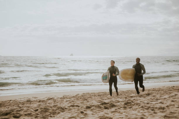 istock Happy friends surfing at the beach 2158212580