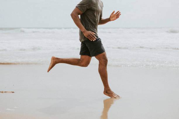 istock Black man running on the beach 2158212583