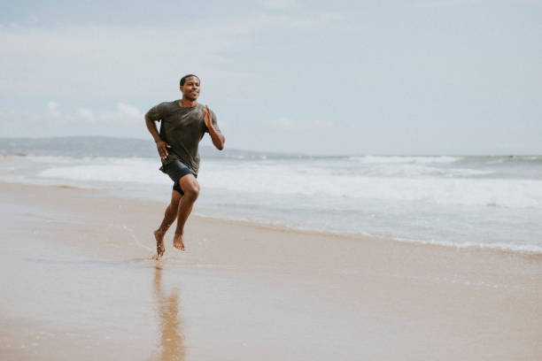 istock Black man running on the beach 2158212601