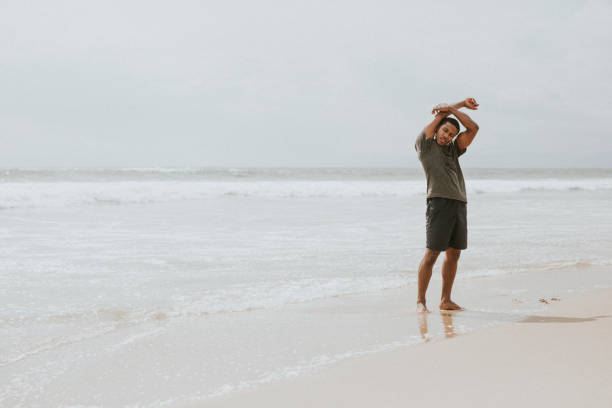 istock Black man stretching on the beach 2158212625
