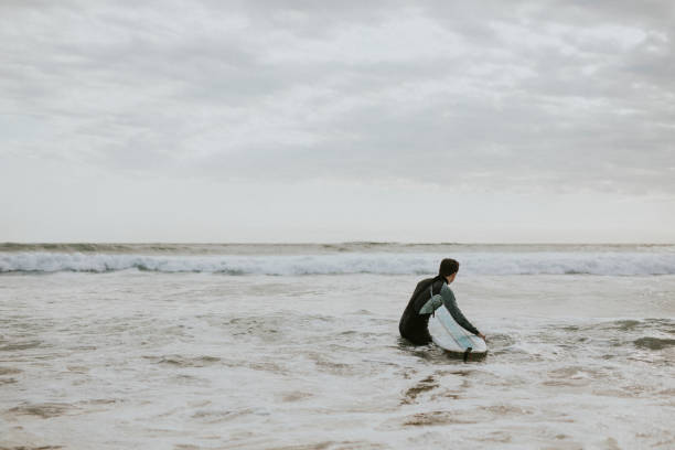 istock Man surfing at the beach 2158212636