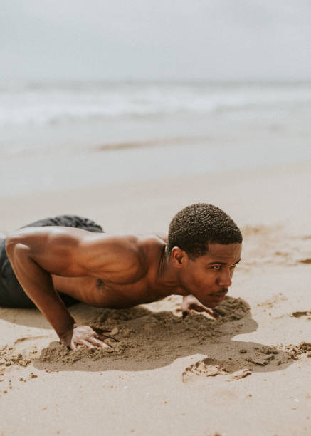 istock Muscular black man doing pushups at the beach 2158212706