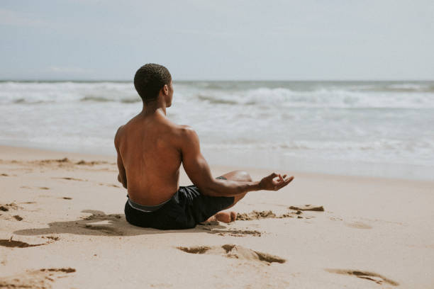 istock Black man meditating at the beach 2158212767