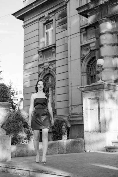 A grayscale shot of a goth girl in an urban setting