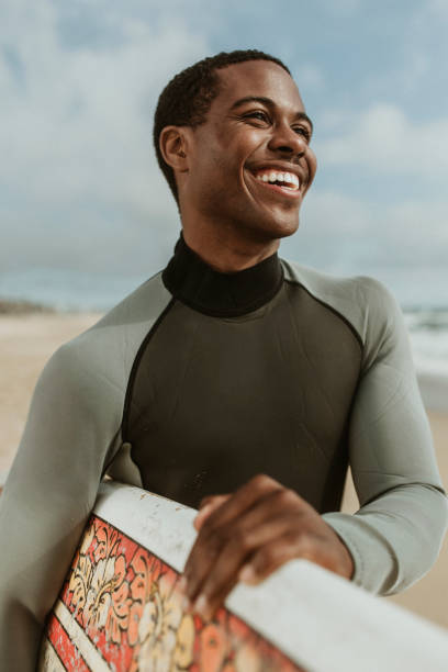 istock Cheerful man with a surfboard at the beach 2158212857