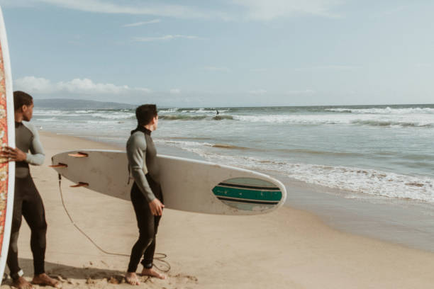 istock Men looking at a surfer at the beach 2158212991