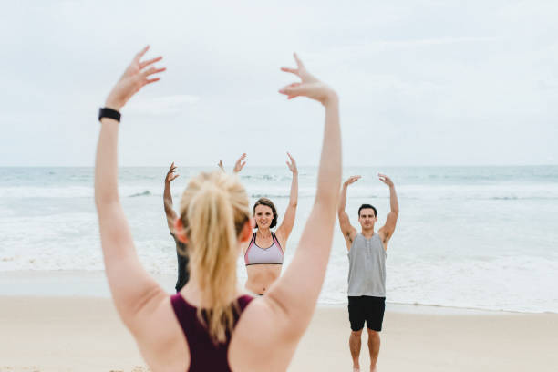 istock Athletic people stretching at the beach 2158213003