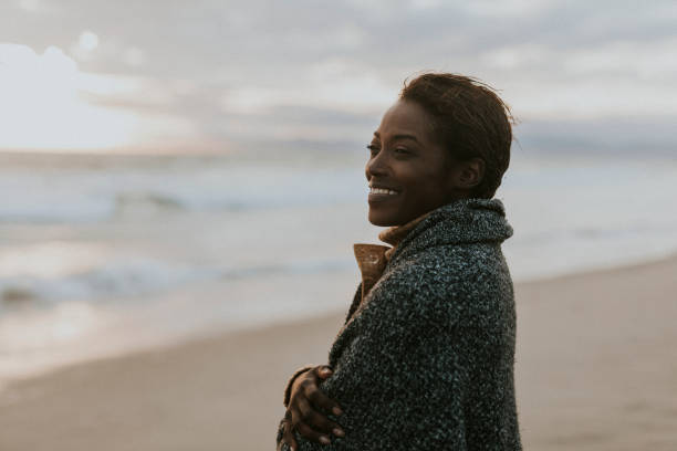 istock Cheerful black woman on the beach at sunset 2158213008
