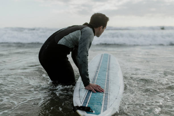 istock Man at the beach with his surfboard 2158213088