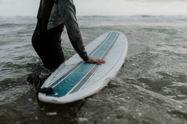 istock Man at the beach with his surfboard 2158213095