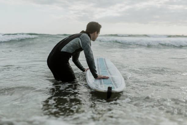 istock Man at the beach with his surfboard 2158213131