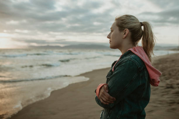 istock Woman on a gloomy beach 2158213749
