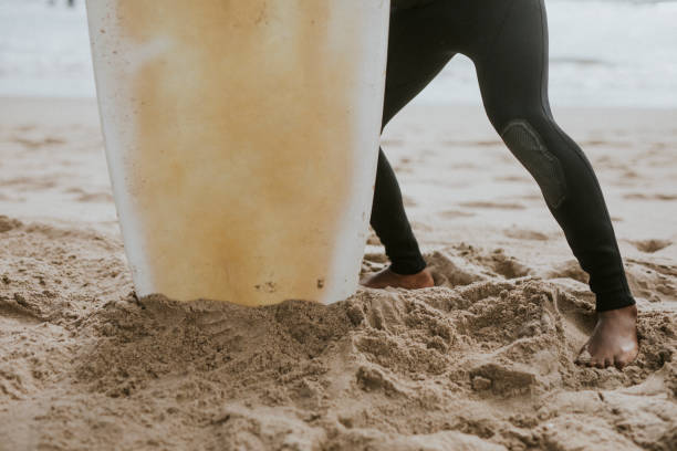 istock Man at the beach with his surfboard 2158213954