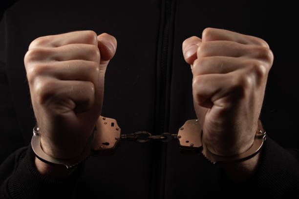 istock Male hands in handcuffs black background 2158214110