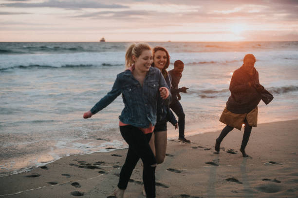 istock Cheerful friends running on the beach 2158214276