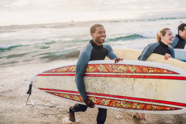 istock Cheerful friends surfing at the beach 2158214457