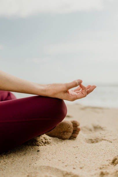 istock Woman meditating on the beach 2158214478