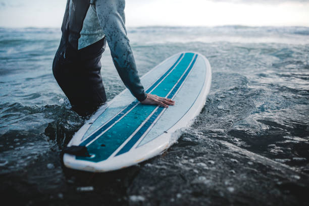 istock Man at the beach with his surfboard 2158214499