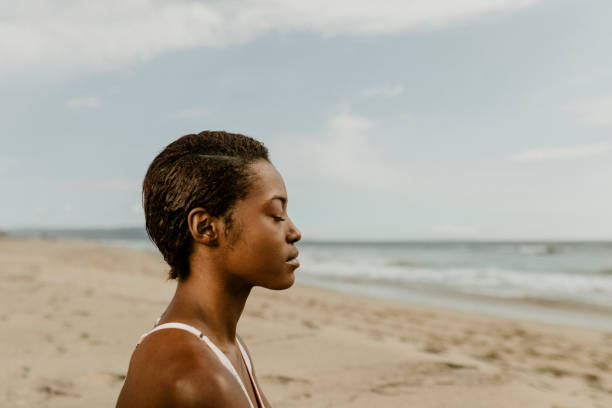 istock Black woman meditating on the beach 2158214542