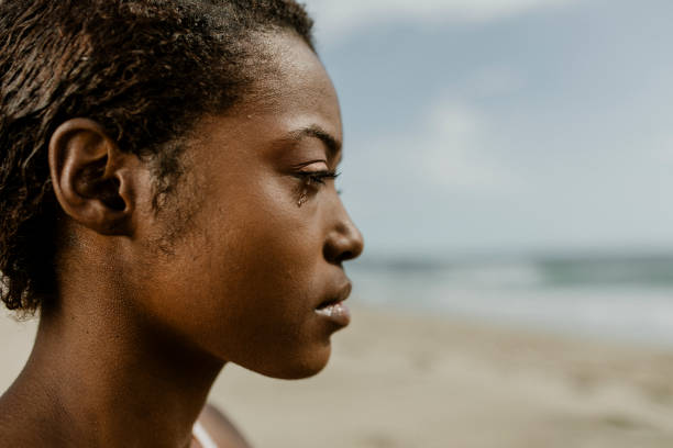 istock Black woman meditating on the beach 2158214566