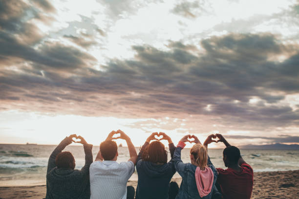 istock Friends making love heart hands at the beach 2158214570