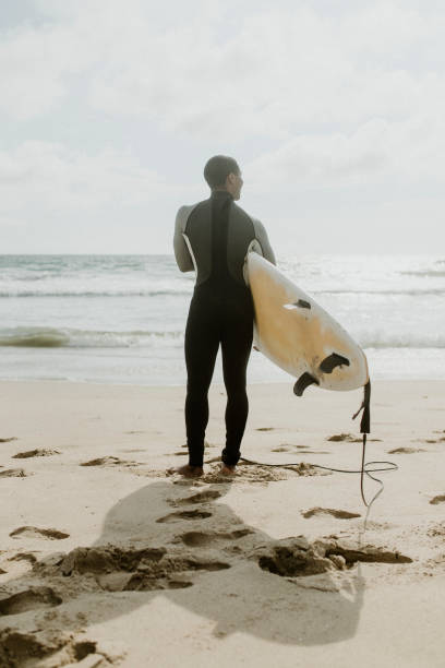 istock Man at the beach with his surfboard 2158214726