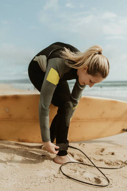 istock Happy woman wearing a surfboard leash 2158214736