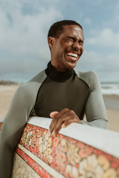 istock Cheerful man with a surfboard at the beach 2158214764