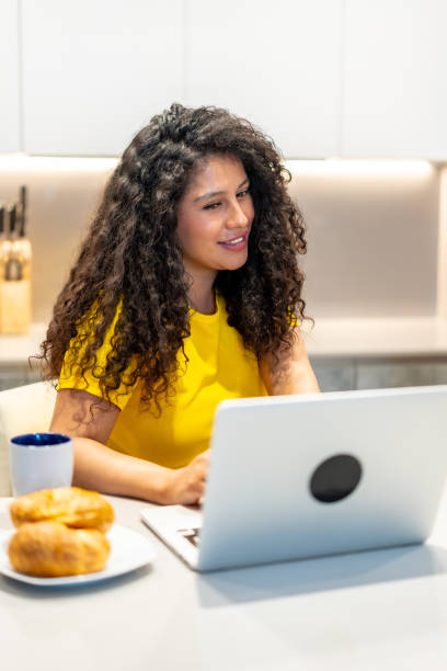 istock Woman eating breakfast and attending a video call at home 2158214979