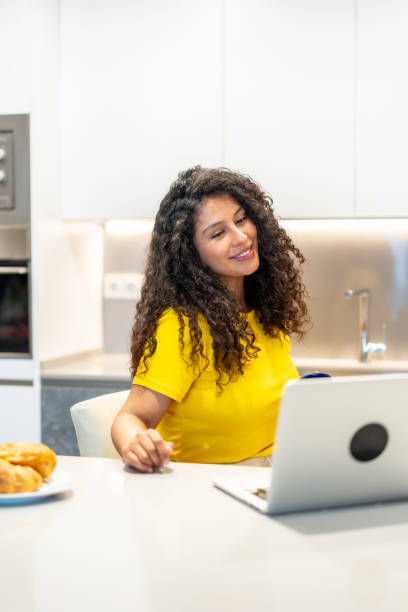istock Smiling woman attending online meeting while drinking morning coffee 2158215089