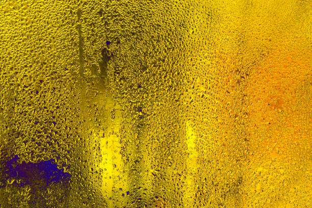Wet glass. water drops yellow background