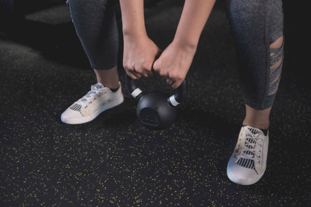 istock A young anonymous woman does a set of goblet squats with a kettlebell. Training at a modern gym. 2158216742