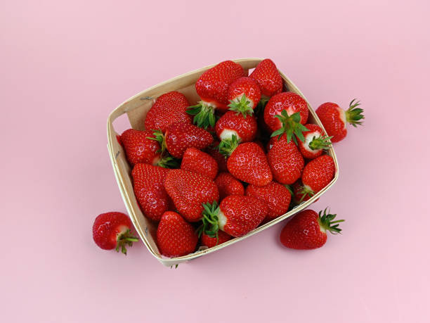 istock punnet of strawberries, close-up, on a pink background 2158217985