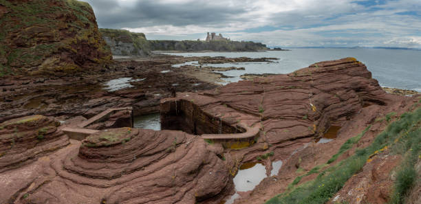 View of Seacliff Harbour near North Berwick with Tantallon Castle in background View of Seacliff Harbour, carved in the rock of the cliffs near North Berwick, Scotland, with Tantallon Castle in background north berwick scotland east lothian castle scotland stock pictures, royalty-free photos & images