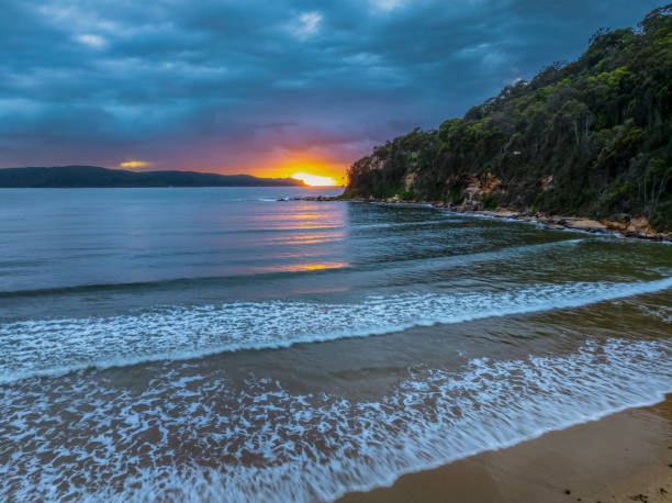 istock Sunrise seascape with rain clouds and flat surf 2158221211