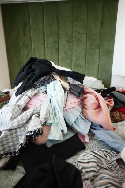 istock messy bed with cloths in early morning , messy bed after waking up 2158223445