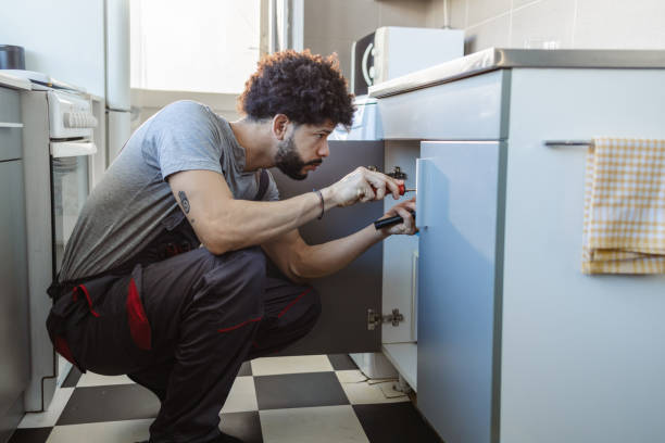 istock Hispanic young plumber repairs a broken water pipe under the sink 2158223587