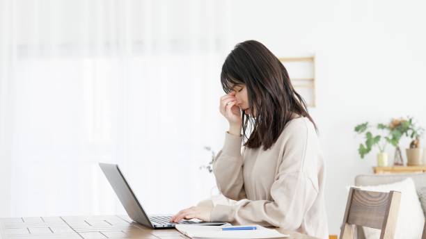 A woman who feels eye strain from working on a computer stock photo