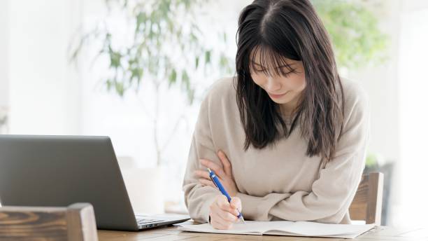 istock A woman studying for a qualification at home 2158223940